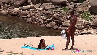 Een goed bedeelde zwarte man benadert een nudist op het strand met gemak vanwege zijn indrukwekkende rijkdom.