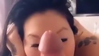 Une femme asiatique sensuelle avec de gros seins rend hommage à son partenaire caucasien tout en attendant